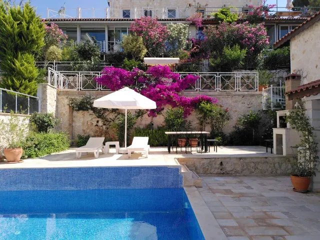 BookNoFees: بيت عطلات في Kalkan, Kas, Antalya, أنطاليا, تركيا – شرفة المسبح مع كراسي استلقاء ومظلة والجهنمية المزهرة على الجدران الحجرية
